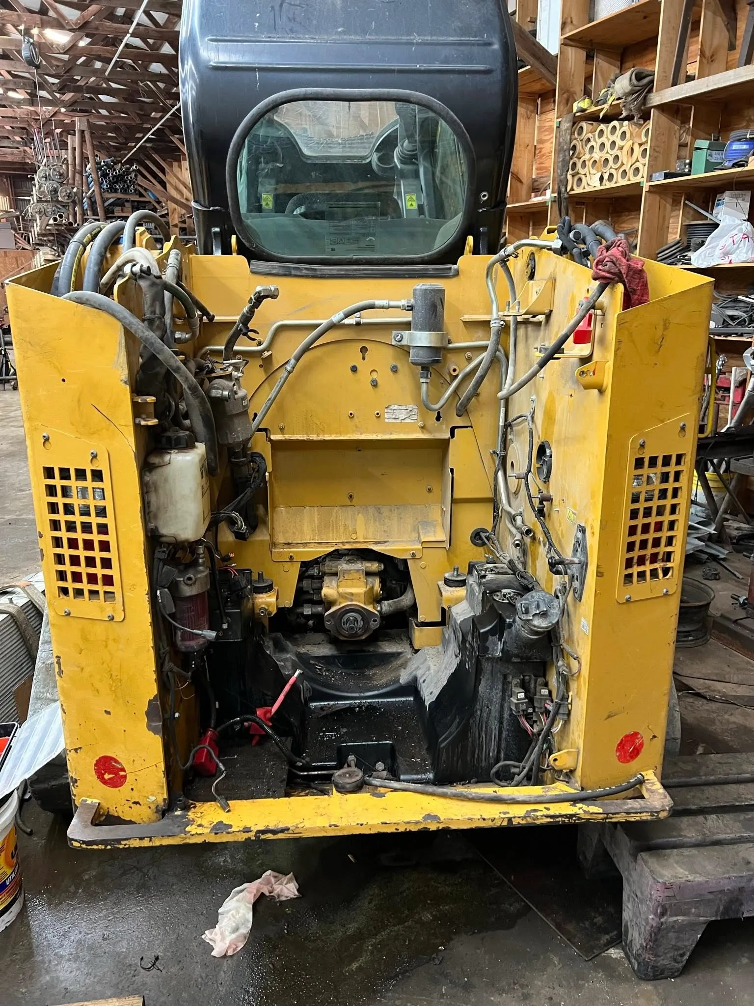 Track loader stripped from the rear for a driveline repair