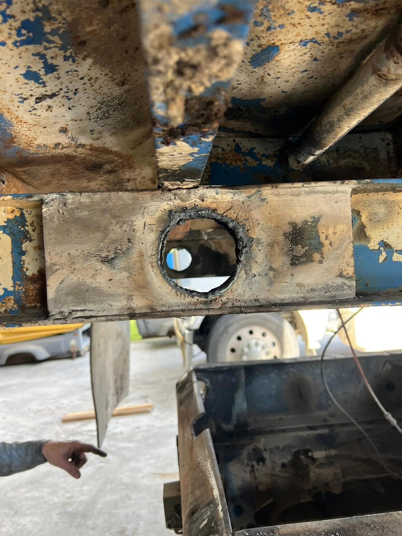 Worn frame section cut open to fit a new bushing sleeve